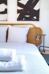een bed met witte lakens en kussens in een slaapkamer bij Studio équipé à 5 minutes de Paris - Montreuil -II in Montreuil