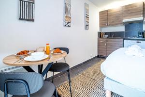een kleine keuken met een tafel en stoelen in een kamer bij Studio équipé à 5 minutes de Paris - Montreuil -II in Montreuil