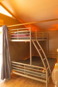 a bunk bed in a room with a ladder at Camping la Rouvière in Chame