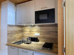 eine Küche mit einer Spüle und einer Mikrowelle in der Unterkunft Appartement Méribel, 2 pièces, 4 personnes - FR-1-411-739 in Les Allues