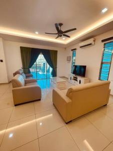 a living room with two couches and a tv at Maxwell Merpati Taiping Homestay in Kamunting