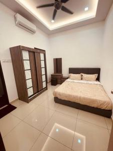 a bedroom with a bed and a ceiling fan at Maxwell Merpati Taiping Homestay in Kamunting