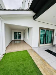 an empty room with a green lawn in a house at Maxwell Merpati Taiping Homestay in Kamunting