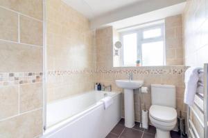 a bathroom with a toilet and a sink and a bath tub at Trendy Sea View 2 bedroom Sleeps 6 - Free Parking in Bournemouth