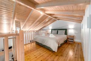 a bedroom with a bed and a wooden floor at Liopetro Suites in Aigio