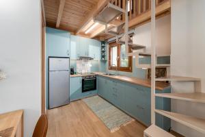 a kitchen with blue cabinets and a wooden ceiling at Liopetro Suites in Aigio