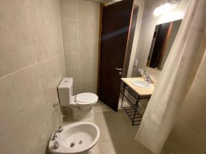ein Badezimmer mit Toilette und Waschbecken in der Unterkunft Hotel El Faro in Villa Gesell + 38 Fotos