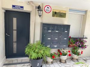 a black door with potted plants in front of a house at Résidence Chene in Viry-Châtillon
