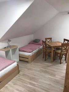 a room with a bed and a table and chairs at Apartmány v Chalupě nad Modravou in Modrava