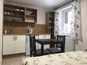 - une petite cuisine avec une table et des chaises dans la chambre dans l'établissement Apartmány v Chalupě nad Modravou, à Modrava