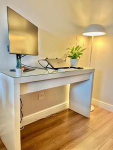 a white desk with a laptop and a lamp at IFSC Room in Dublin