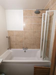 a bath tub in a bathroom with a shower at Mews Cottage in Hartington