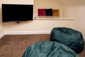a living room with a flat screen tv on a wall at Modern 4 Bed House with Parking in Swadlincote
