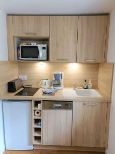 a small kitchen with a sink and a microwave at Charmante petite maison 2 personnes in Chambourg-sur-Indre