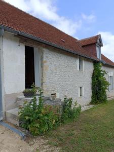 Charmante petite maison 2 personnes في Chambourg-sur-Indre: منزل من الطوب الأبيض مع نافذة وباب