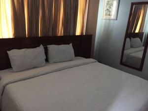 AbeokutaにあるMERCY HAVEN Abeokutaのベッドルーム1室(白いシーツと鏡付きのベッド1台付)