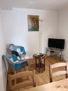 Charmante petite maison 2 personnes في Chambourg-sur-Indre: غرفة معيشة مع كرسي وطاولة