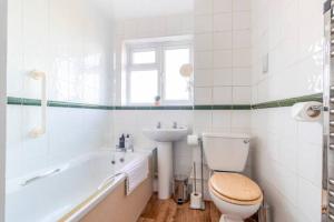 a bathroom with a toilet and a sink and a tub at Large Sea View 2 bedroom Sleeps 6 - Free Parking in Bournemouth