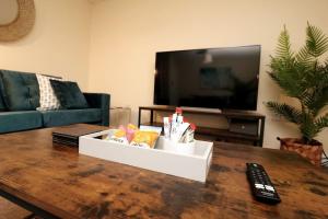 a living room with a coffee table and a tv at Modern 4 Bed House with Parking in Swadlincote