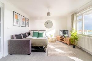 um quarto com uma cama, um sofá e uma televisão em Large Sea View 2 bedroom Sleeps 6 - Free Parking em Bournemouth