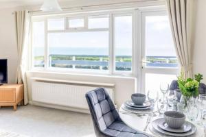 a dining room with a table and chairs and a window at Large Sea View 2 bedroom Sleeps 6 - Free Parking in Bournemouth