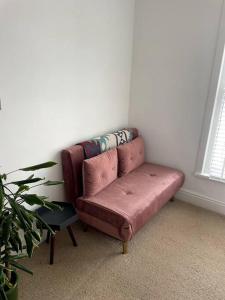 un sofá sentado en la esquina de una habitación en Home in West by the Sea, en Llanelli