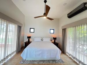a bedroom with a bed and a ceiling fan at Hotel Manglares in Celestún