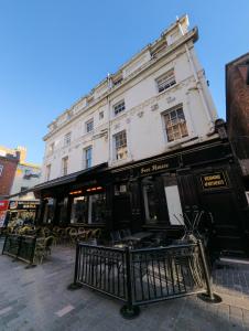 a large white building with tables and chairs on a street at Richmond Apartment in Liverpool