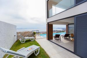 une maison avec un balcon et une piscine dans l'établissement Luxury villa Astraeus 2 near Split, private pool, à Podstrana