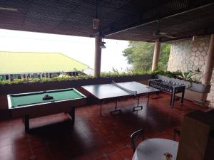 a patio with two ping pong tables and chairs at Ribiera del Lago Peten Itza in Flores