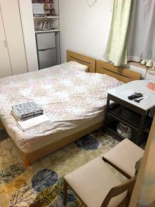 a bedroom with a bed with a table and two chairs at Sunny moe oo in Tokyo