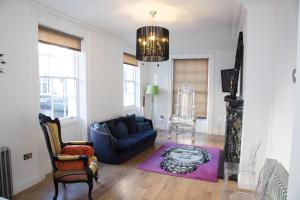 Richmond Apartment في ليفربول: غرفة معيشة مع أريكة زرقاء وسجادة أرجوانية