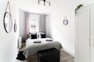 a white bedroom with a bed and a mirror at Apartament Starołęcka Warta Residence PARKING included in Poznań