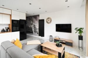 a living room with a couch and a table at Apartament Starołęcka Warta Residence PARKING included in Poznań