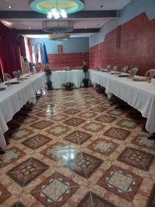 a banquet hall with white tables and chairs at Ribiera del Lago Peten Itza in Flores
