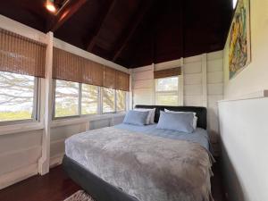 a bedroom with a bed in a room with windows at La Dama de los vientos in Cerro Azul