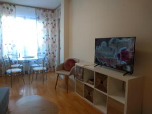 sala de estar con TV y mesa de comedor en TO FOUR+2 PREDELA 1, en Bansko