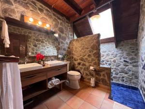 a stone bathroom with a sink and a toilet at La Dama de los vientos in Cerro Azul