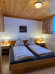 a bedroom with a bed with two pillows on it at Wirtshäusl Maria Alm in Maria Alm am Steinernen Meer