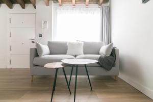 ein Wohnzimmer mit einem Sofa und einem Tisch in der Unterkunft Aqua Apartments Málaga in Málaga