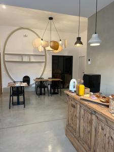 a kitchen with a counter and tables and chairs at Le Chai in Nissan-lez-Enserune
