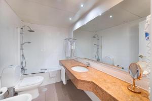 a bathroom with a sink and a toilet and a mirror at Urban Hotel Amadeos in Matosinhos