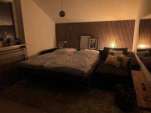 een slaapkamer met een bed en een bank bij Lichtdurchflutete Dachgeschoss-Wohnung mit großem Balkon in Bruckmühl