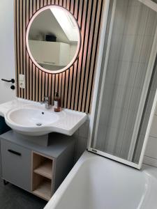 een badkamer met een wastafel en een spiegel bij Lichtdurchflutete Dachgeschoss-Wohnung mit großem Balkon in Bruckmühl