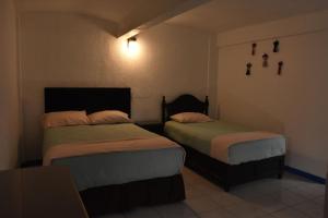 Un dormitorio con dos camas en una habitación. en Casa Gris Alemán, en Oaxaca City
