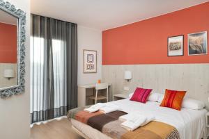 a bedroom with a large bed and a mirror at Apartamentos Torre del Reloj in Jaca