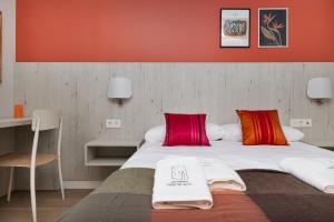 a bedroom with two beds with red walls at Apartamentos Torre del Reloj in Jaca
