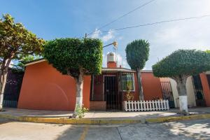 een oranje gebouw met bomen ervoor bij Casa Gris Tule in Tule