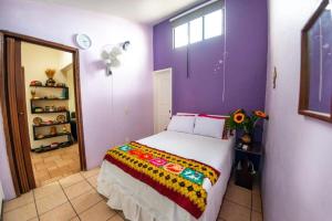 a bedroom with a bed with a colorful blanket at Casa Gris Tule in Santa María del Tule