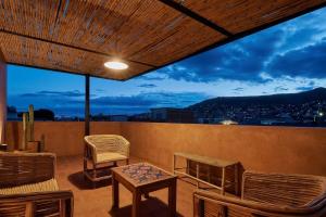 uma varanda com cadeiras, uma mesa e uma vista em Hermosa casa ubicada en Oaxaca em Oaxaca de Juárez
